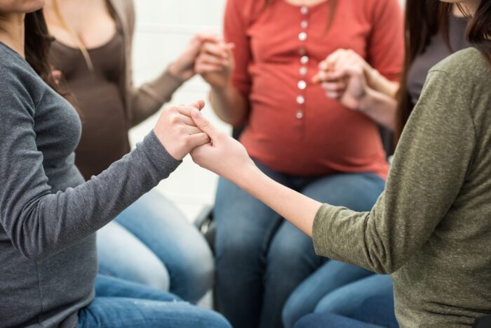 circle of pregnant people holding hands