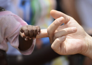 child holding onto an adult's finger