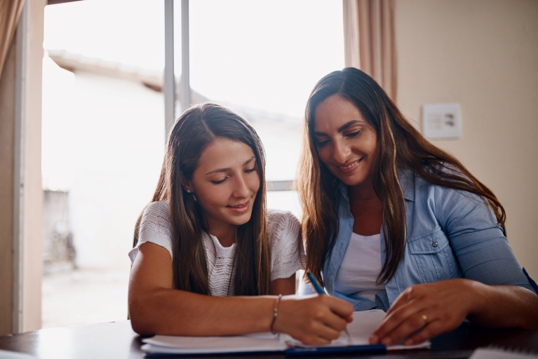 woman helping a teen girl with homework