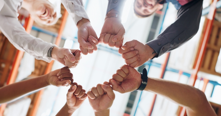 a bunch of people holding their closed hands together to form a circle