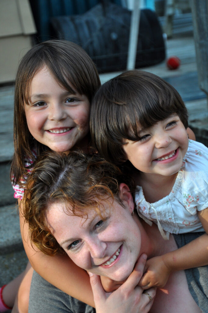 woman smiling with a pair of children
