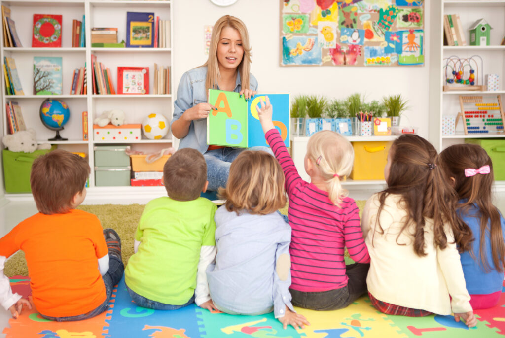 woman teaching the alphabet to young students